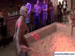 Two sexy girls are wrestling in the mud while other babes watch