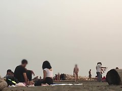 Clothed women walk past naked guy with tiny dick on beach